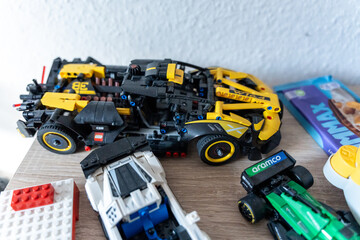 Obraz premium Warsaw, Poland - Sep 4, 2026: LEGO Technic construction vehicle set with a Milka chocolate bar on a wooden floor