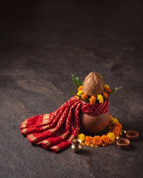 Minimal Navratri still life featuring red chunri, coconut, kalash and marigold flowers on stone surface for premium festival invitation design