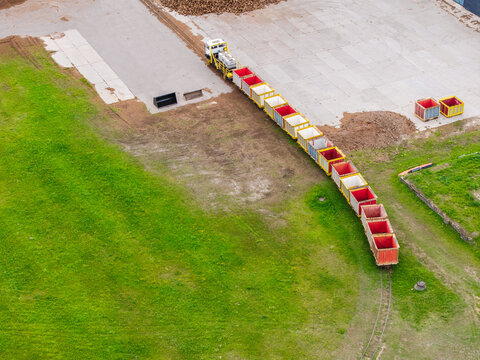 Aerial view of a small industrial train pulling open-top wagons along a narrow-gauge track through the Lielsalu purvs peat bog in Lielsalas, Talsi Municipality, Latvia.