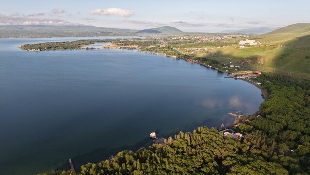 Aerial view of Lake Sevan with its expansive blue waters, surrounding green hills, and coastal vegetation in Sevan, Gegharkunik Province, Armenia.