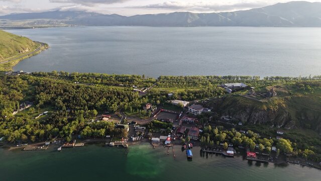 Aerial view of Lake Sevan with its surrounding lush greenery, historic monastery on the hill, and calm waters in Sevan, Gegharkunik Province, Armenia.