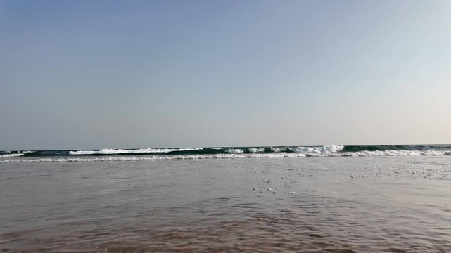 Gentle Ocean Waves Rolling Across Smooth Wet Sand on an Empty Tropical Beach