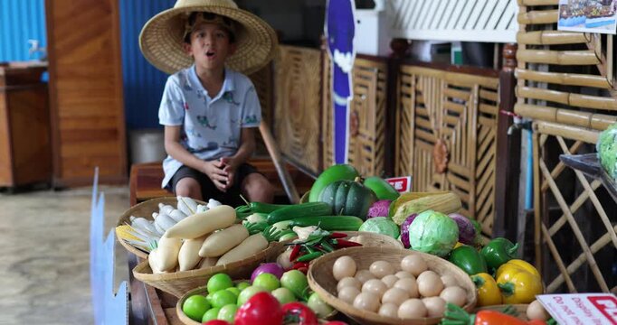 School kid boy enjoy eat food in traditional floating market travel in Thailand