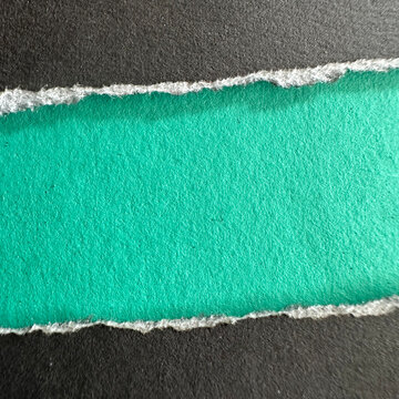 Torn black paper strip revealing a bright teal background