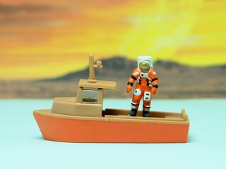 Mini toy of action figure at outdoor with blur background. Miniature photography concept design. Minifigure of Astronaut character landing at new red planet. Exploring space with boat at mars sea © awstoys