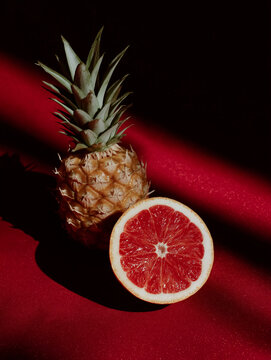 Surreal Pineapple and Grapefruit Hybrid in Dramatic Red Light. Perfect for tropical food branding and creative wellness campaigns.