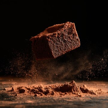 A rich chocolate brownie levitates with cocoa powder exploding around it