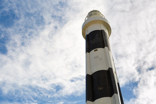 Black and White Lighthouse Against Cloudy Sky