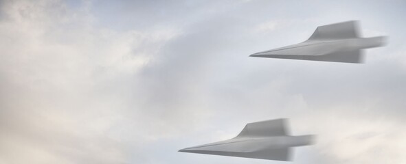 Two sleek aircraft soar through a cloudy sky. They glide with precision, leaving no visible trail. The motion blur suggests high speed and agility. Ideal for aviation, defense, or futuristic themes © Issarawat Tattong