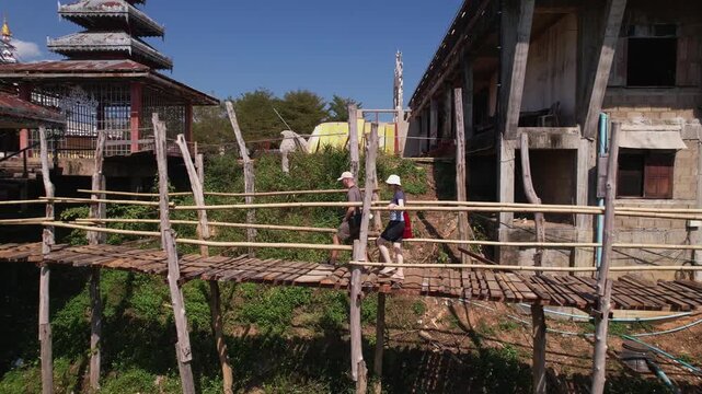 Couple walking on bamboo bridge to pavilion in Mae Hong Son Thailand