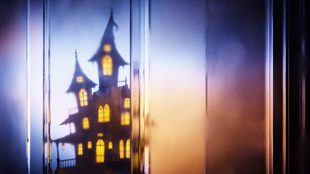 Halloween haunted house glowing behind layered vertical glass panels.