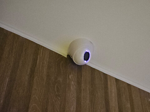 Security camera installed in a corner of a room observing