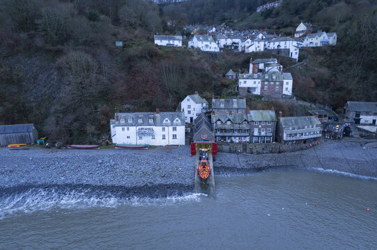 Clovelly, United Kingdom - 09 January 2022: Aerial view of RNLI Clovelly Lifeboat Station on the pebble beach of the historic fishing village, with traditional white cottages on the steep hillside.