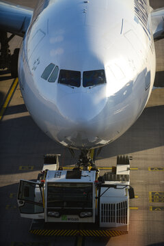 Beograd, Serbia - 08 January 2014: Aerial view of a commercial airplane nose being pushed back by a tug vehicle on the tarmac at Belgrade Nikola Tesla Airport.