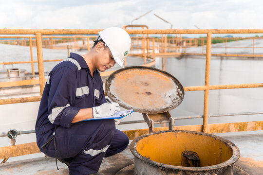 Petrochemical Engineers checking reports for technical inspections in oil refinery. Technicians working on checklist in the oil storage tank area. Factory and industry manufacturing. Oil tank.