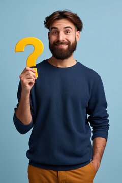 Smiling bearded man holding a yellow question mark cutout on teal background for faq poster and promotional banner design