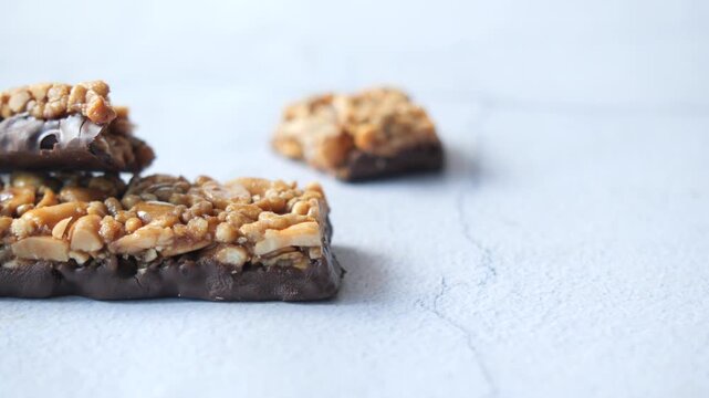 Close-up of chocolate peanut butter protein bars on light background healthy snack bar motion footage