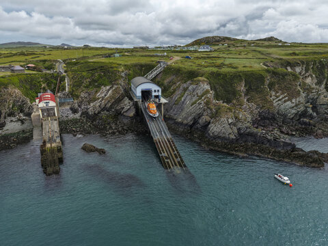 St Davids, United Kingdom - 16 May 2026: Aerial view of St Justinian's lifeboat station with a lifeboat on the slipway, rugged coastal cliffs, and the sea under a cloudy sky.