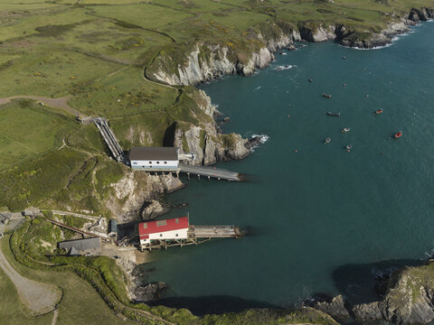 St Davids, United Kingdom - 14 May 2026: Aerial view of St Justinian's lifeboat station situated on the rugged coastline with turquoise waters, small boats, and green grassy cliffs.