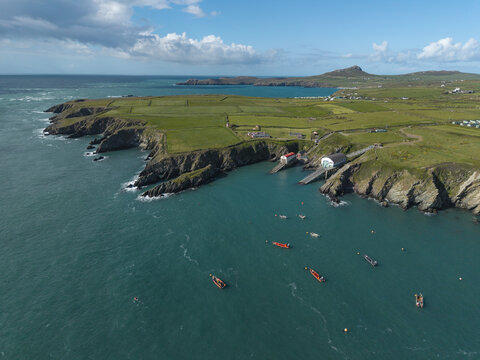 St Davids, United Kingdom - 14 May 2026: Aerial view of St Justinian's lifeboat station on the rugged coastline, with small boats anchored in the turquoise bay, green fields, and rocky cliffs.