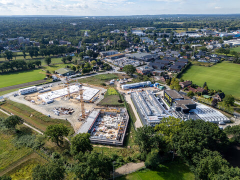 Rellingen, Germany - 02 September 2026: Aerial view of a data center facility under construction with cranes, building foundations, and surrounding green fields in a suburban area.