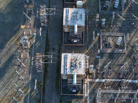 Croydon, Australia - 02 September 2026: Aerial view of Croydon Zone Substation with electrical transformers, high voltage power lines, and metal structures casting long shadows in the morning light.