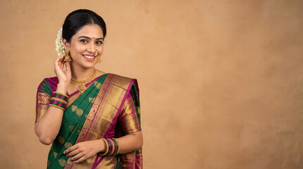 Fototapeta premium Young beautiful indian woman in traditional saree and gold jwellery