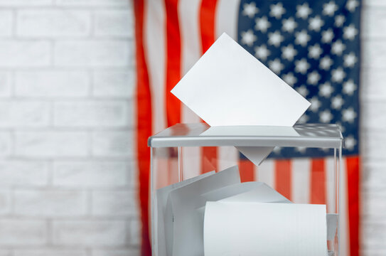 US election banner with voting ballot entering a transparent voting box, the US flag in the background with copy space, symbolizing American elections and democracy.