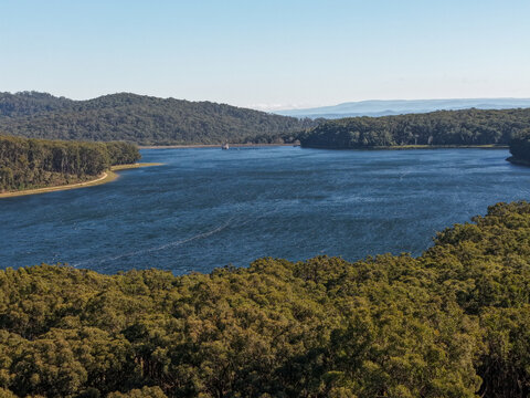 Silvan, Victoria, Australia - 01 September 2026: Aerial view of Silvan Reservoir Park surrounded by dense eucalyptus forests and rolling hills under a clear blue sky.