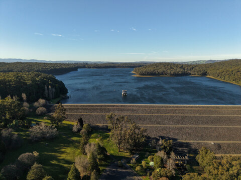 Silvan, Victoria, Australia - 01 September 2026: Aerial view of Silvan Reservoir Park, featuring the dam wall, expansive water, and surrounding dense eucalyptus forest under a clear sky.