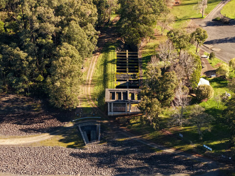 Silvan, Victoria, Australia - 01 September 2026: Aerial view of Silvan Reservoir Park showing the concrete spillway structure surrounded by dense eucalyptus forest and grassy parkland.