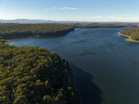 Silvan, Victoria, Australia - 01 September 2026: Aerial view of Silvan Reservoir Park surrounded by dense eucalyptus forests and rolling hills under a clear blue sky.