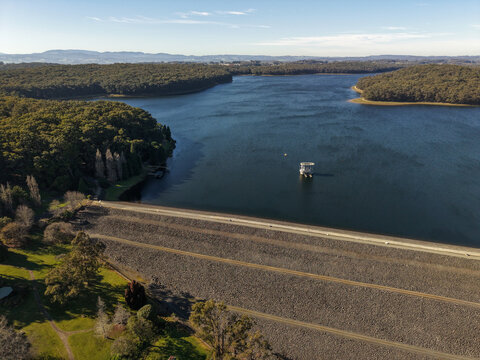 Silvan, Victoria, Australia - 01 September 2026: Aerial view of Silvan Reservoir Park, featuring the large dam wall, the reservoir water, and surrounding dense forest under a clear sky.