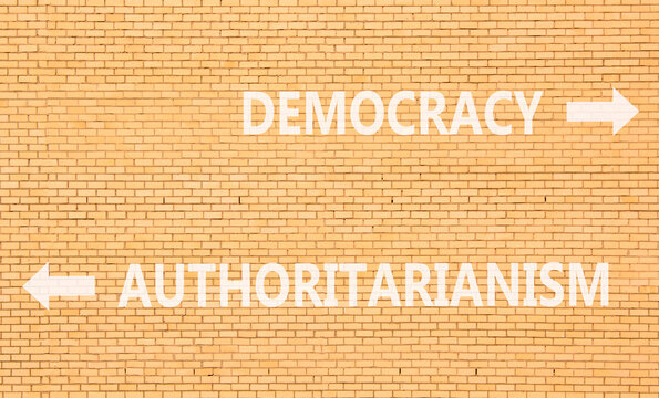 Democracy or authoritarianism symbol. Concept words Democracy Authoritarianism on beautiful brick wall. Beautiful brick wall background. Business democracy authoritarianism concept. Copy space