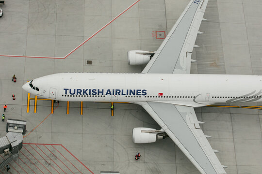 Arnavutkoy, Turkiye - 31 August 2026: Aerial view of a Turkish Airlines aircraft parked at the gate at Istanbul Airport with ground crew and apron markings visible.