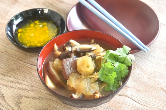 braised fish maw with bamboo shoot and pork blood with chicken meat in red gravy soup on bowl dipping spicy sour chili sauce