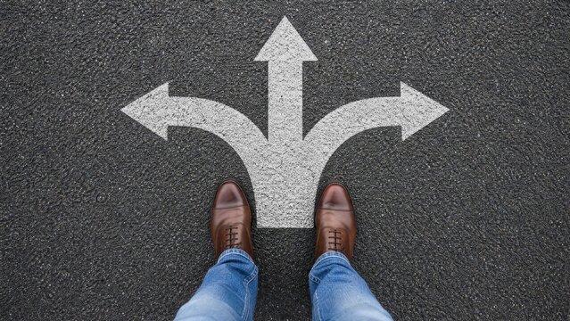 Feet standing on asphalt at three-way direction arrow