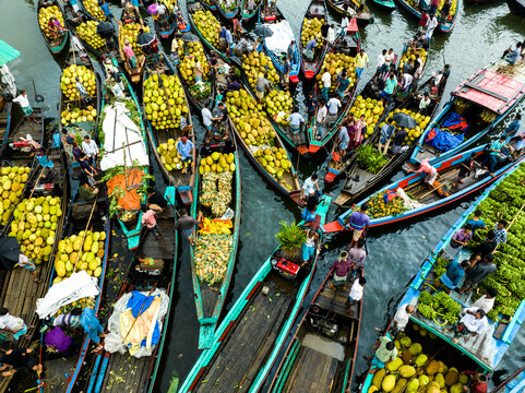 Rangamati, Bangladesh - 31 May 2025: Aerial view of a bustling floating market featuring numerous wooden boats heavily laden with ripe jackfruit, with local vendors and shoppers navigating the river.