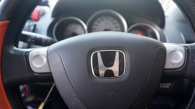 Purwokerto, Indonesia - 20 June 2026: Honda steering wheel closeup with dashboard gauges in background.