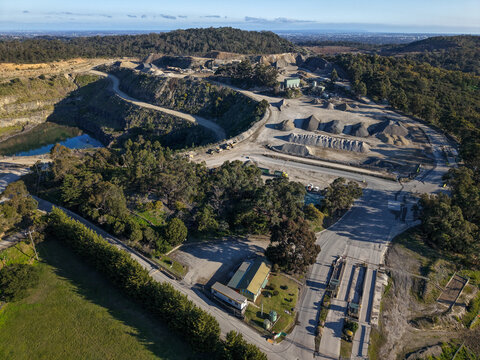 Lysterfield, Australia - 30 August 2026: Aerial view of Boral Quarries showing the open-pit mine, gravel stockpiles, access roads, and surrounding forest landscape.
