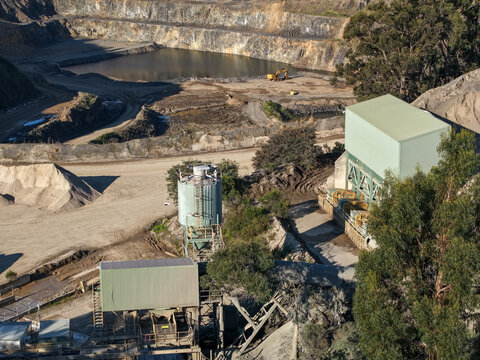 Lysterfield, Victoria, Australia - 30 August 2026: Aerial view of Boral Quarries with industrial processing facilities, gravel stockpiles, and a deep excavation pit with a pond.