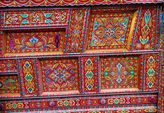 View of intricate and vibrant traditional truck art patterns featuring floral motifs and geometric designs on a vehicle body in Dera Ghazi Khan, Punjab, Pakistan.