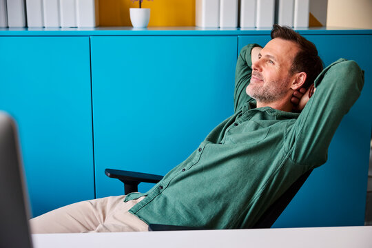 A businessman relaxes in his office chair during a break