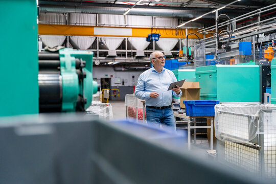 Manager holds a tablet inside the production hall