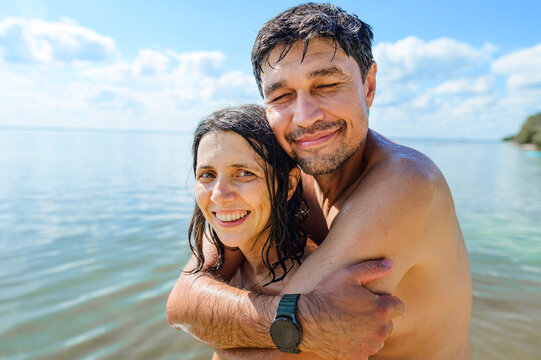Happy man and woman hug in the sea during summer vacation