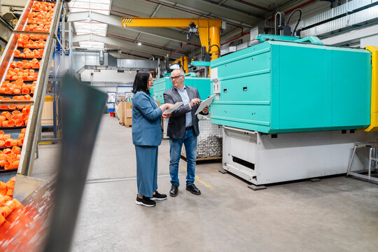 Manager and supervisor discuss planning in the production hall