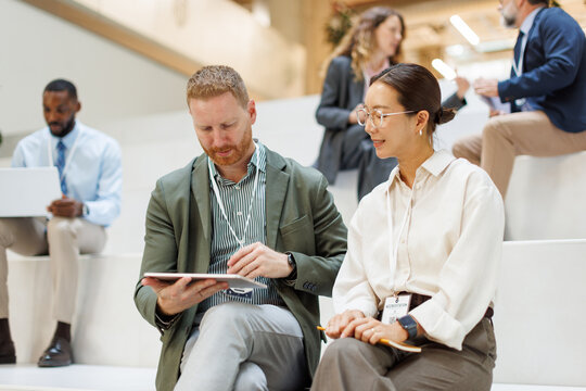 Business colleagues using tablet at conference