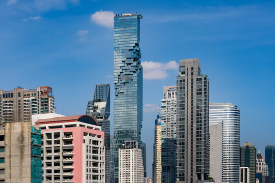 View of the King Power Mahanakhon skyscraper with its distinctive pixelated facade rising above the surrounding urban skyline in Bangkok, Thailand.