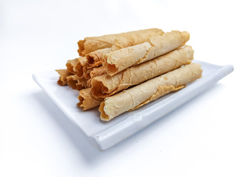 Close-up of (semprong in Indonesia) crispy rolled wafer cookies stacked together and isolated on a clean white background