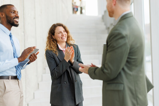 Happy business people clap for success at the corporate office
